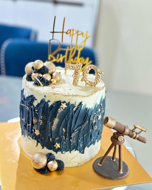 Lovelybakes blue and gold astronomy birthday cake with a telescope topper