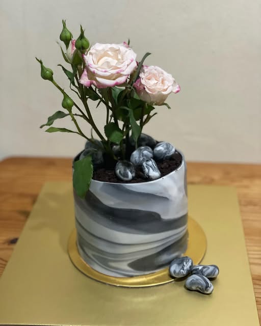A Lovelybakes cake with marbled buttercream and a bouquet of roses